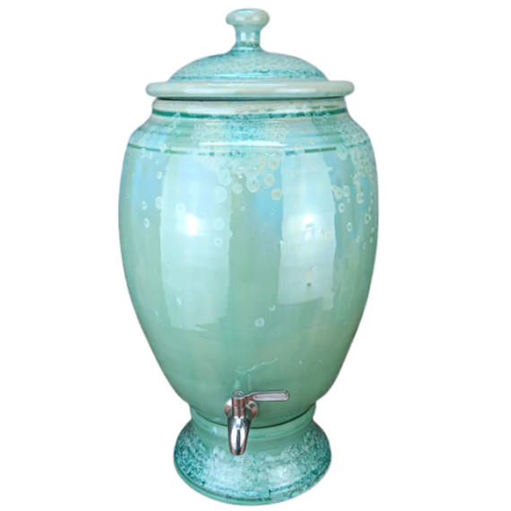 handmade functional green ceramic water dispenser with a stainless spout on a white background