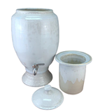 White ceramic drink dispenser with handmade insert and lid on a white background