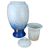 Blue and white ceramic drink dispenser with matching cup on a white background