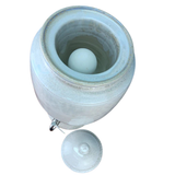 White ceramic container with a lid on a white background