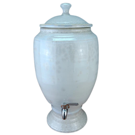 White ceramic beverage dispenser with a silver faucet on a white background