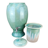 handmade green ceramic water dispenser with matching ceramic insert and lid on a white background.