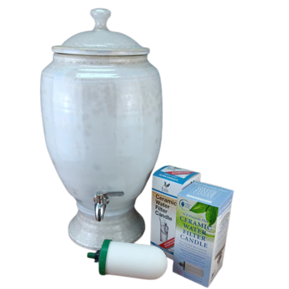 White ceramic water dispenser with a faucet, filter candle, and packaging on a white background